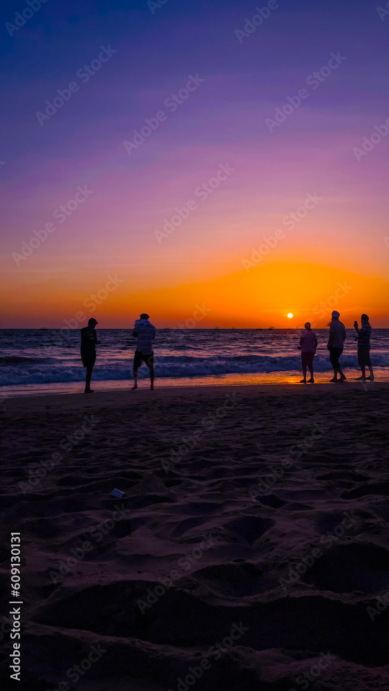 Fototapeta premium People on the beach at sunset
