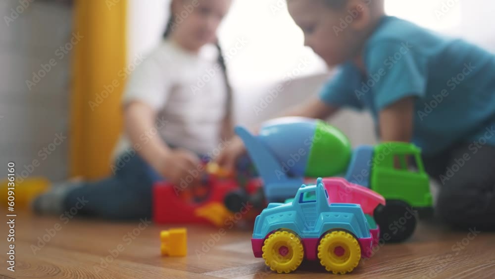children toddler a playing toy car on the floor. happy family kindergarten kid dream concept. children toddler play toys at the window at home close-up. children play toys in kindergarten lifestyle