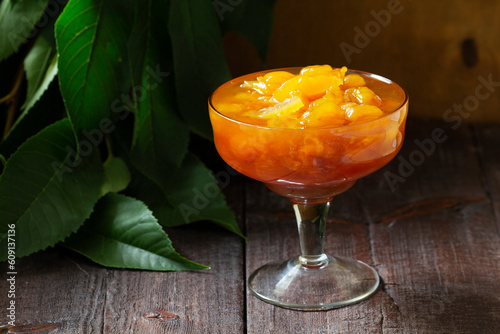 Obraz na płótnie Yellow cherry jam with lemon and vanilla in a glass bowl on a wooden background. w salonie