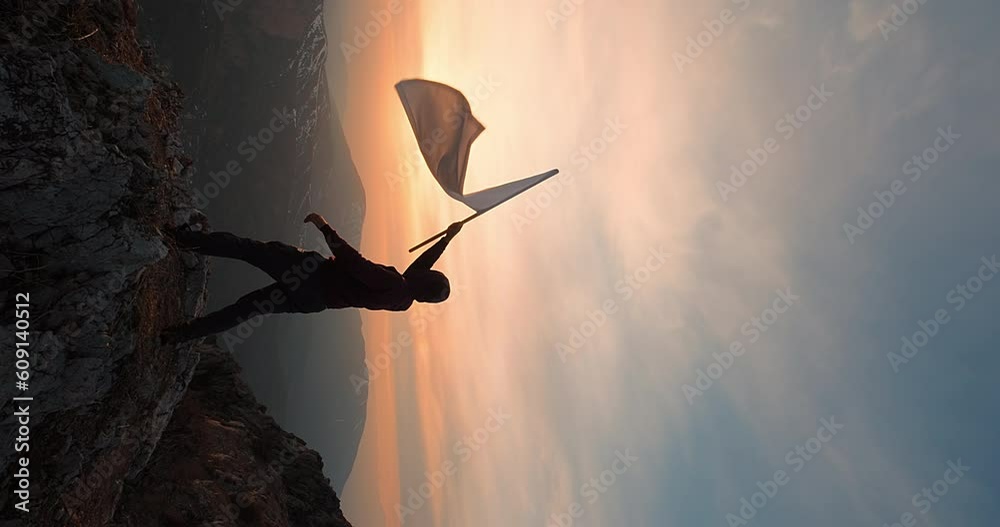 A man waving white flag against sunset dawn. Concept of peace and freedom