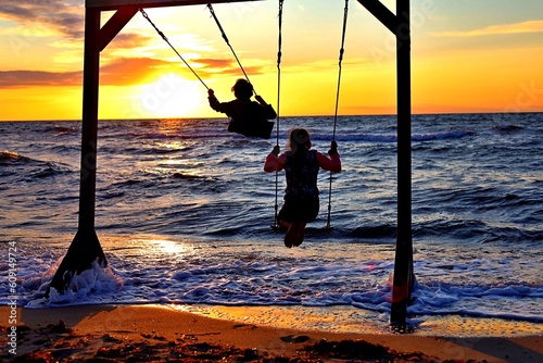 kids swinging in the sunset