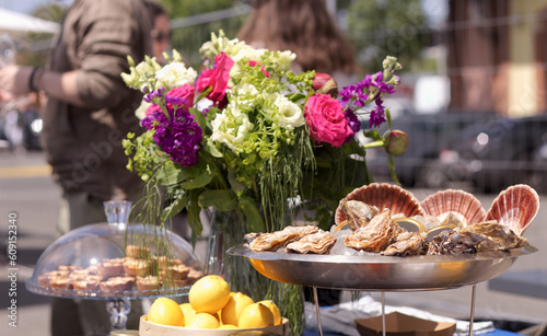 Photography The selection of French delicacies, focused on metal bowl with fresh oysters  displayed at the French wine and food street festival in Prague Holesovice,  selective focus