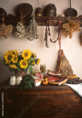 Italian salami and a vase of Sunflowers with dry flowers hunging form top photo