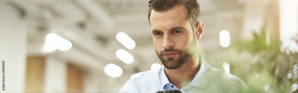 Fototapeta premium Enjoying morning coffee at work and checking e-mail