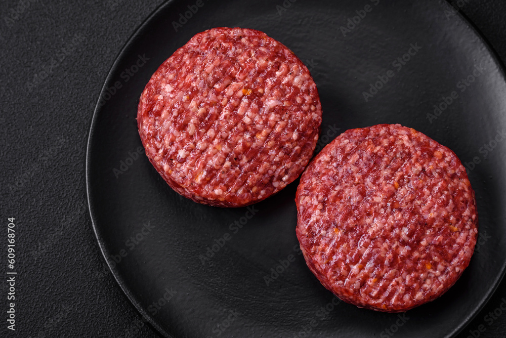 Fresh raw ground beef burger patty with salt and spices Fresh raw ground beef burger patty with salt and spices