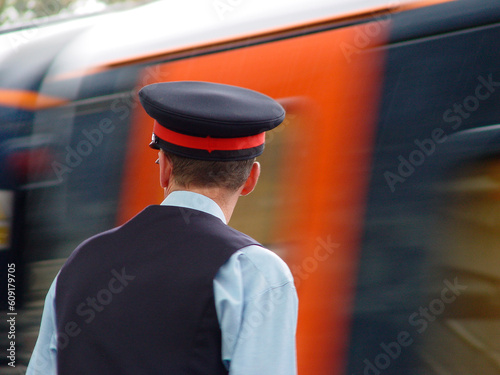 A station master overlooking departing train at Durham station, UK