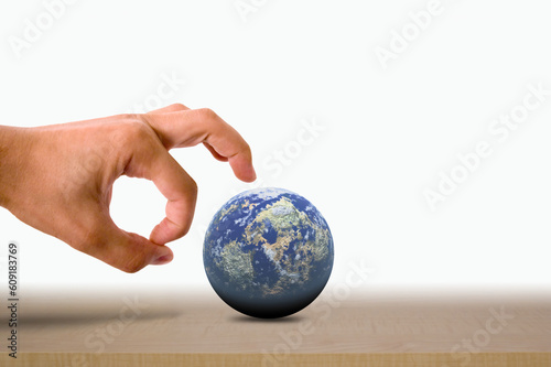 Male hand flicking the earth on a wooden surface