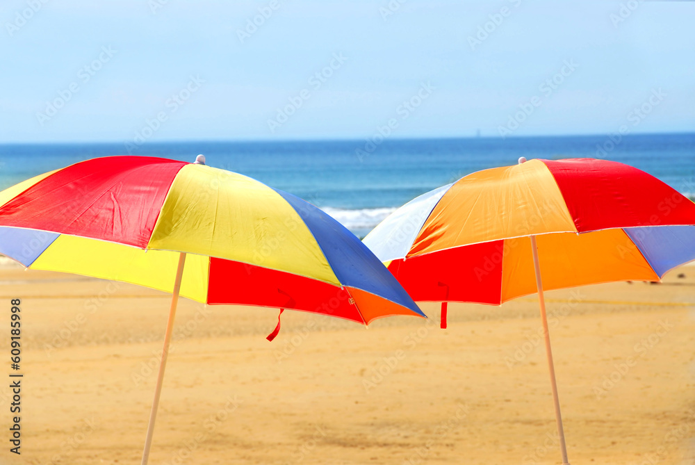 Two beach ubrella standing on ocean shore