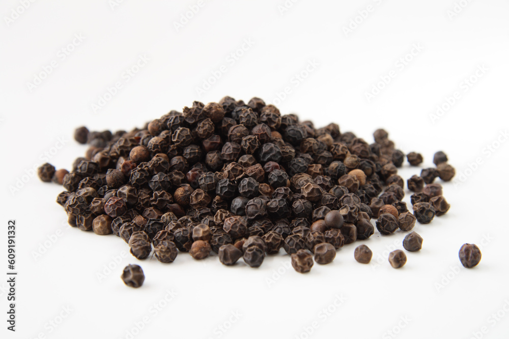 Whole black pepper, isolated on white. Shallow depth of field, focused on the centre of the pile. Whole black pepper, isolated on white. Shallow depth of field, focused on the centre of the pile.