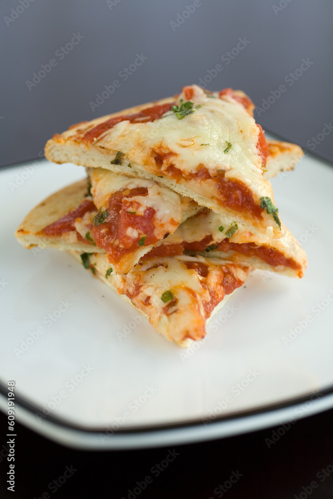 Slices of plain pizza stacked on a plate