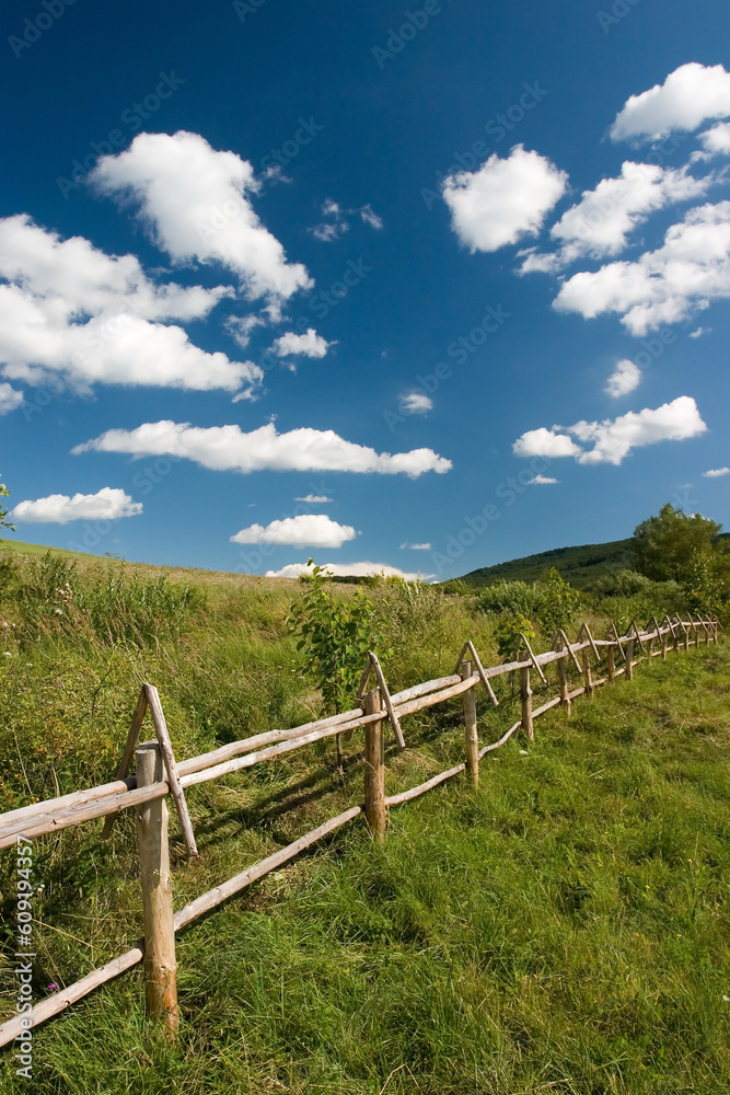 East European summer landcape with wooden fence and beautiful clouds