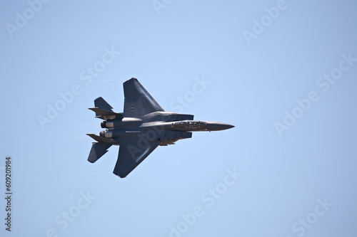 F-15 strike eagle in flight against blue sky, banking hard right