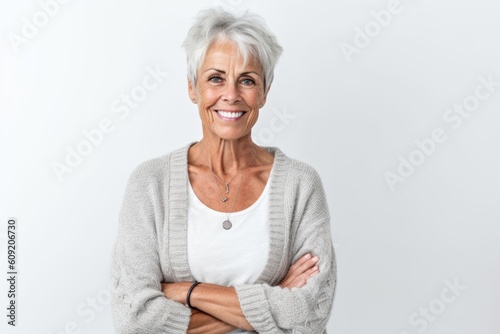 Portrait of a happy senior woman standing with arms crossed over white background