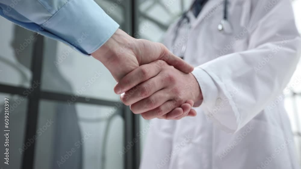 Business partners shaking hands in meeting hall Business partners shaking hands in meeting hall