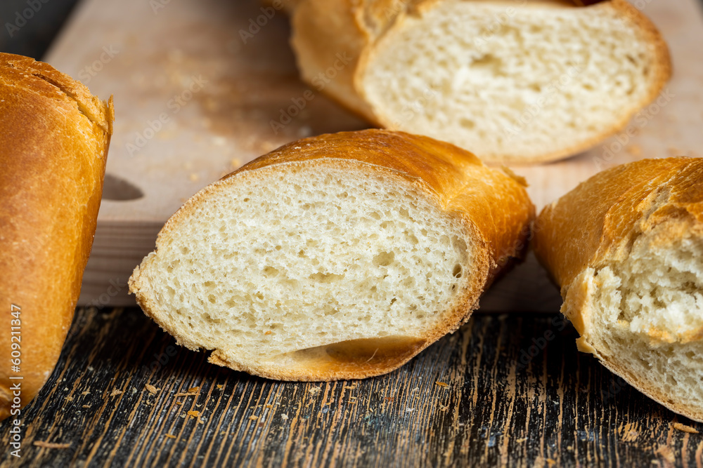 Naklejka premium pieces of soft baguette on a cutting board