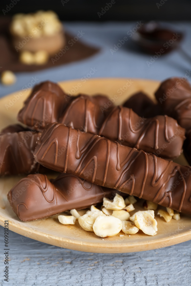 Sweet tasty chocolate bars with nuts on grey wooden table, closeup Sweet tasty chocolate bars with nuts on grey wooden table, closeup