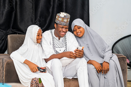 Happy African Muslim family looking at a cellphone