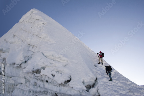Two climbers about to summit Island Peak in Nepal. The peak is very close to Everest and Lhotse. This picture was taken in in the middle of October at 6:45am. photo