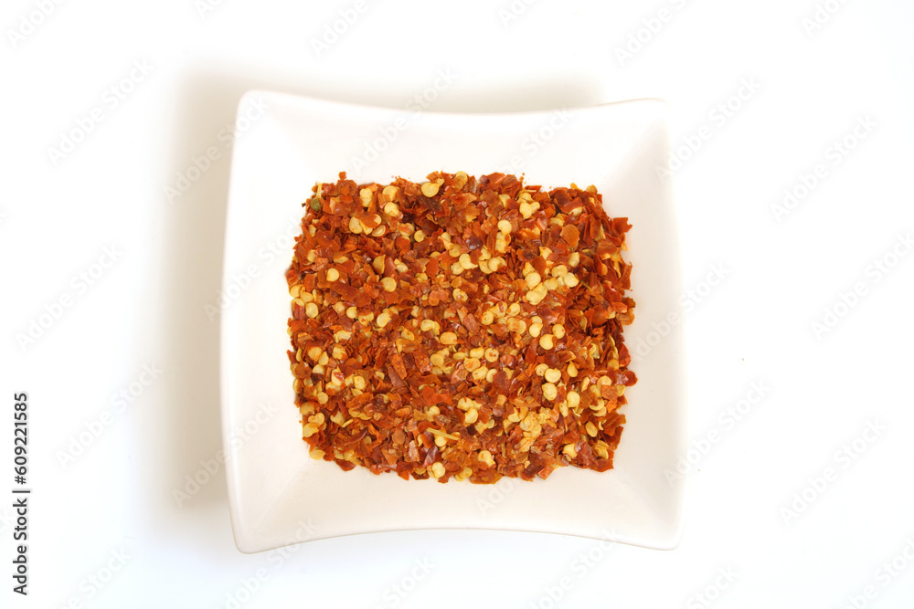 crushed chili pepper in square white bowl isolated crushed chili pepper in square white bowl isolated