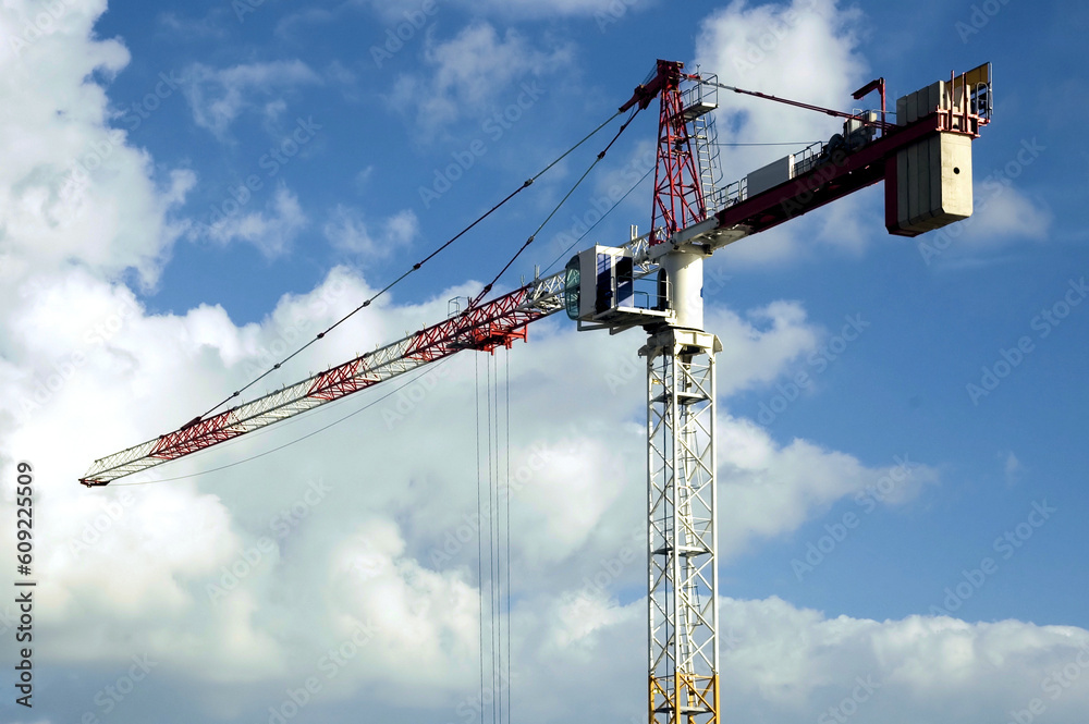 High rise crane with a cloudy blue sky backdrop High rise crane with a cloudy blue sky backdrop
