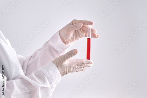 Test tube with blood in the hand.