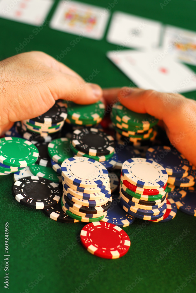 Poker player raking a big pile of chips Poker player raking a big pile of chips
