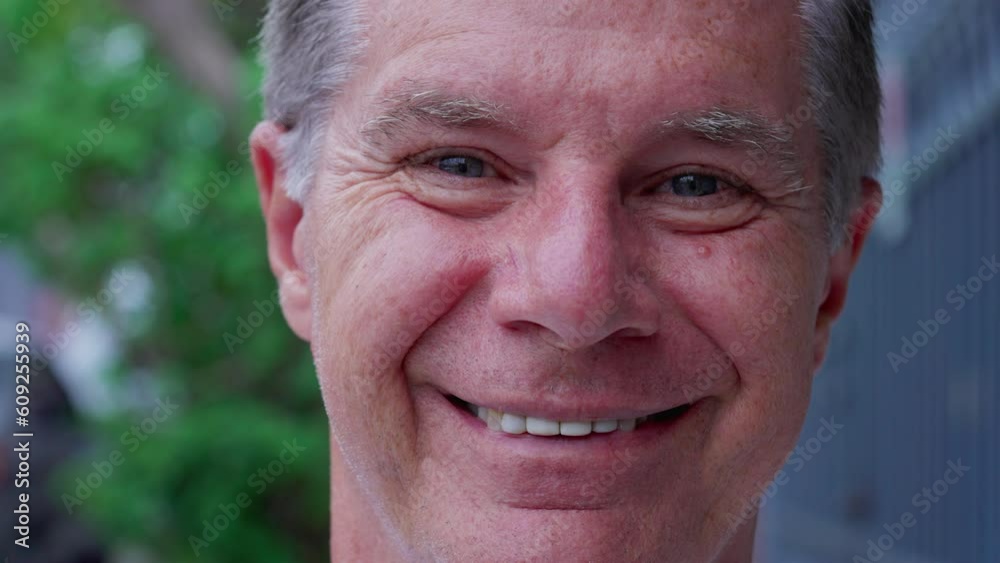 Happy middle-aged man macro close-up face looking at camera smiling Happy middle-aged man macro close-up face looking at camera smiling