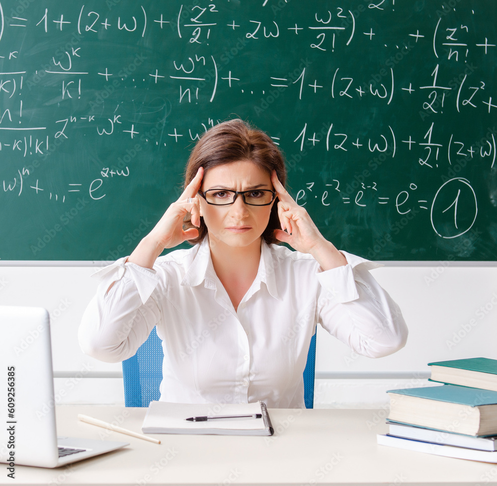 Female math teacher in front of the chalkboard Female math teacher in front of the chalkboard