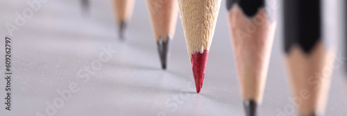 Tablou pe pânză Red pencil stands out from crowd of many identical black pencils