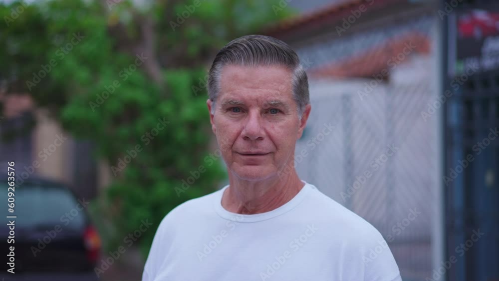 Portrait of a middle-aged man standing in street looking at camera. Close-up face of an older male caucasian person in 50s. Tracking shot Portrait of a middle-aged man standing in street looking at camera. Close-up face of an older male caucasian person in 50s. Tracking shot