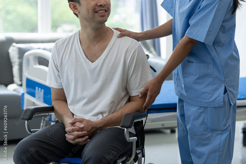 Fototapeta premium Rehabilitation specialist or physiotherapist giving physical training instruction to male patient in wheelchair at rehabilitation center The concept of physical therapy and health insurance.