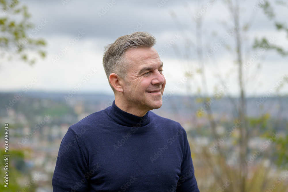 Man wearing a blue sweater standing on a mountain Man wearing a blue sweater standing on a mountain
