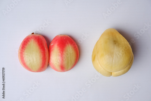 two slightly reddish zalacca or Salacca zalacca fruits and slightly off-white salak fruit which have been peeled