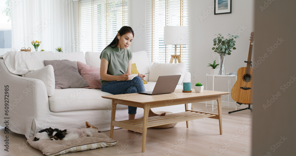 Reskill upskill for young adult talent workforce remote work at home hybrid workplace. Asia woman happy smile sit at sofa couch learn online study MBA video call share plan idea write note on tablet.