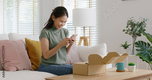 Obraz na płótnie Young asia people happy girl smile unbox open gift buy order from online store shop take photo shoot camera post social media IG reel app show youth lifestyle blog share sit relax at home sofa couch