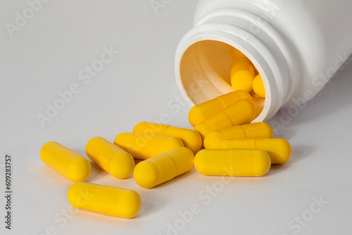 Upside down medicine jar in yellow capsules. Full depth of field. 