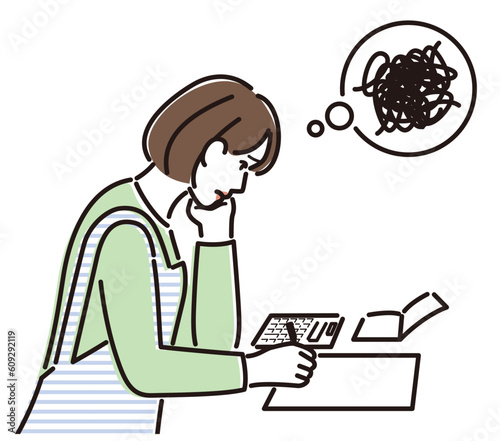家計簿をつけて思い悩む女性