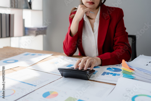 Young asian female work with financial papers at home count on calculator before paying taxes receipts online, planning budget glad to find chance for economy saving money, audit concepts. photo