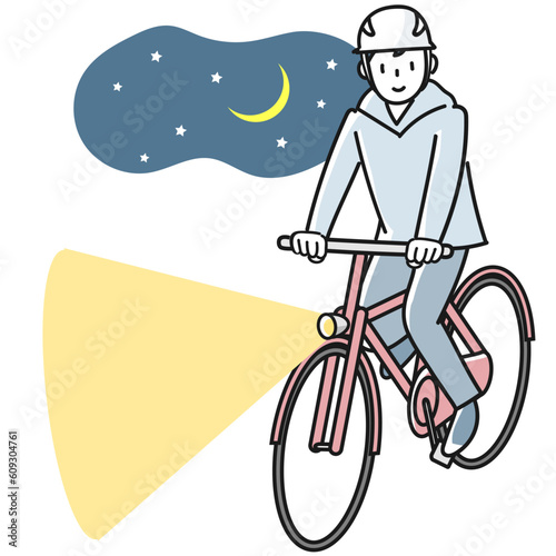 夜間にライトを点けて自転車で走る若い男性