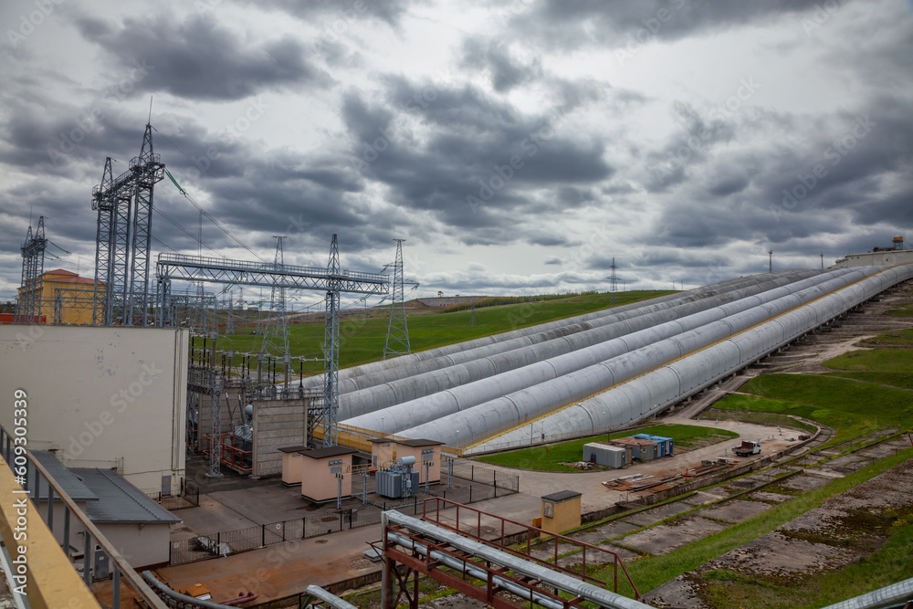 hydro power plant pipes and electric substation on grey sky background hydro power plant pipes and electric substation on grey sky background