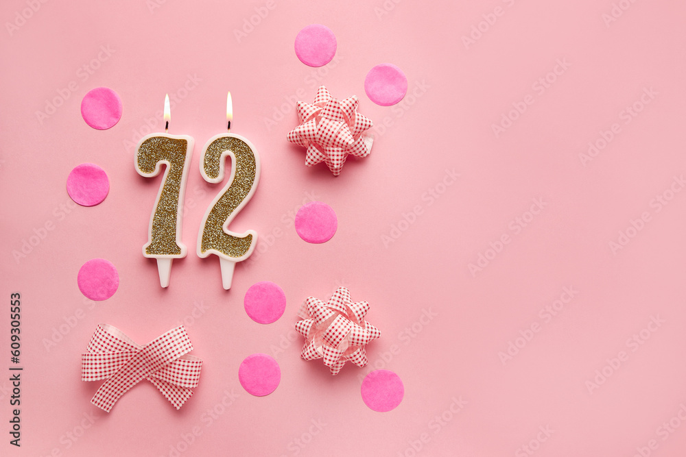 Number 72 on pastel pink background with festive decor. Happy birthday candles. The concept of celebrating a birthday, anniversary, important date, holiday. Copy space. banner