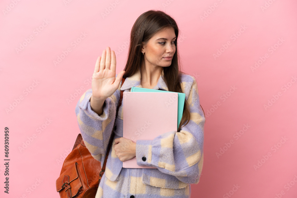 Young student woman isolated on pink background making stop gesture and disappointed Young student woman isolated on pink background making stop gesture and disappointed