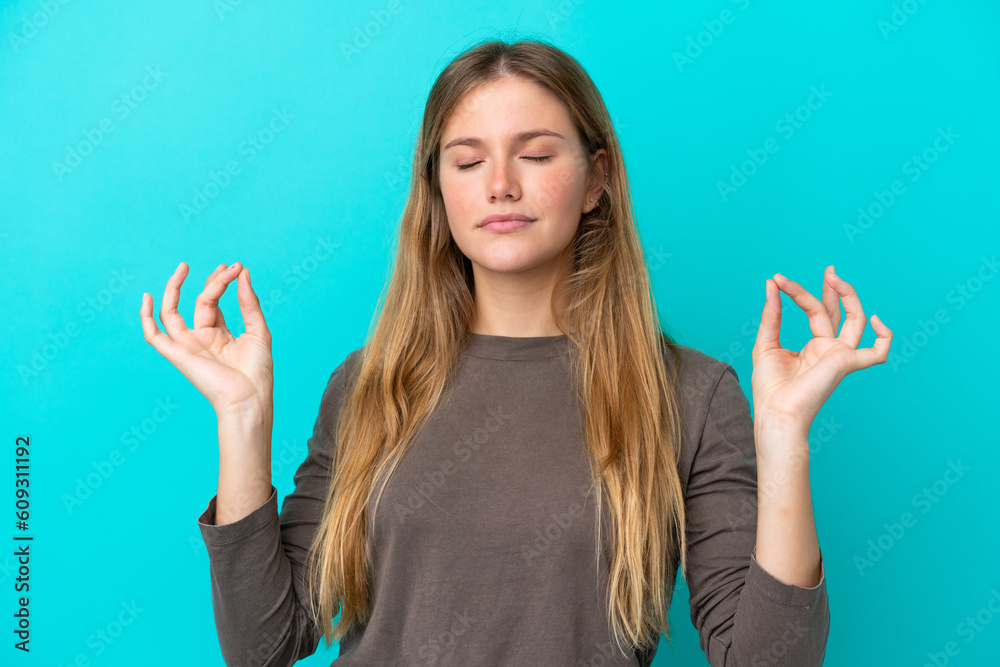 Young blonde woman isolated on blue background in zen pose Young blonde woman isolated on blue background in zen pose