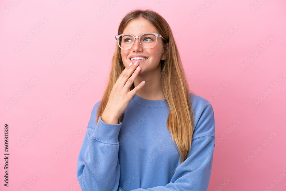 Young blonde woman isolated on pink background With glasses and thinking while looking up Young blonde woman isolated on pink background With glasses and thinking while looking up