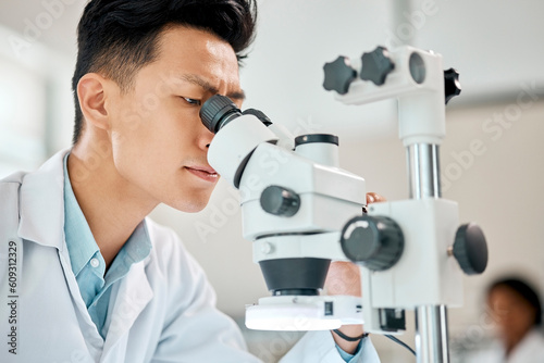 Medical, science and microscope with an asian man doctor working in a lab for research or innovation. Healthcare, investigation and experiment with a male scientist in a laboratory for analysis