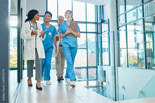 Healthcare, doctors and nurses walking together for discussion, planning or schedule. Diversity, men or women medical group talking about support strategy, medicine and surgery teamwork in hospital photo