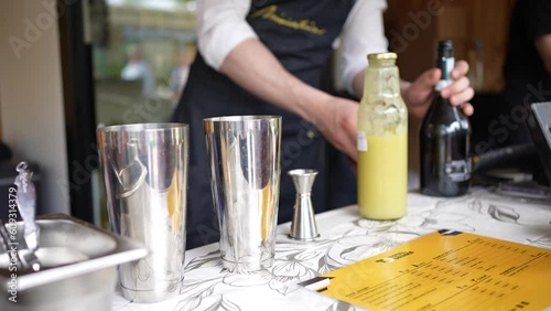 Bartender taking a bottle out of a fridge and opening it on the counter