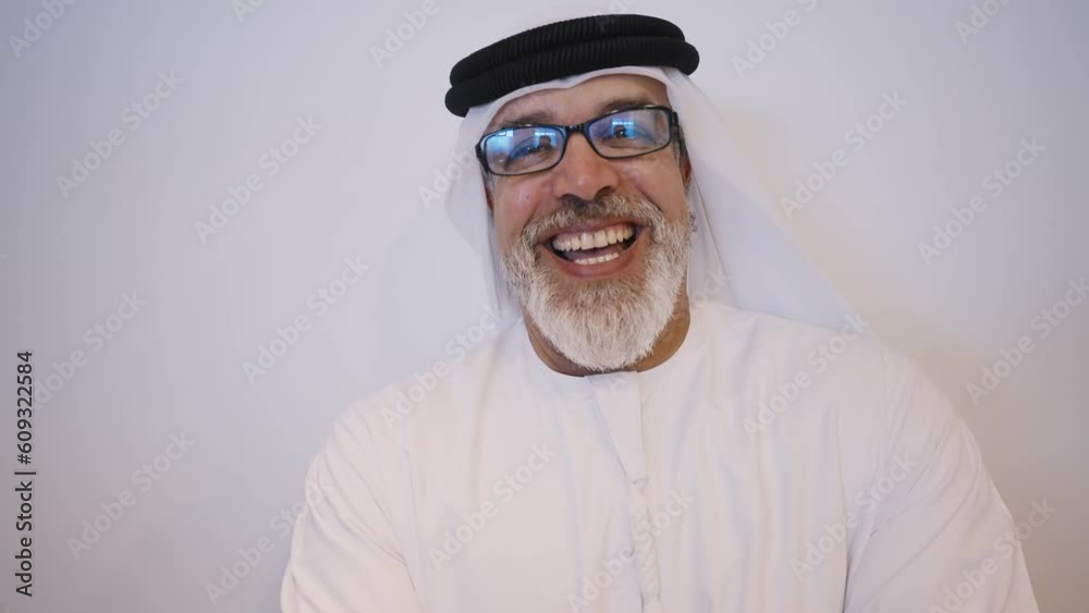 Business men from dubai working in an office. Business people of the emirates wearing the traditional white kandura outfit Business men from dubai working in an office. Business people of the emirates wearing the traditional white kandura outfit
