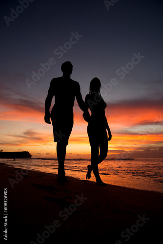 silhouette of a couple walking on the beach