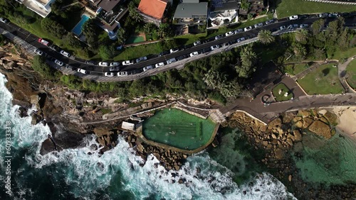 People swimming in Bronte Baths ocean pool with waves crashing.